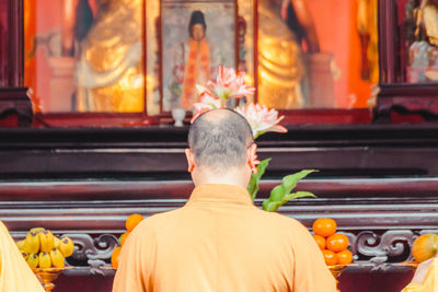 Rear view of man sitting outside building