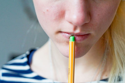 Close-up of woman touching lips with pen at home