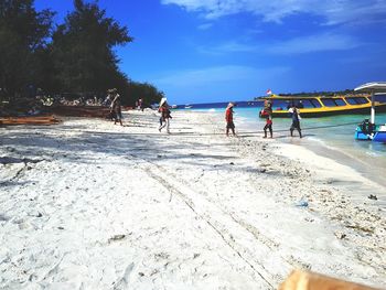 People at beach against sky