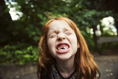 Close-up of girl clenching teeth at park