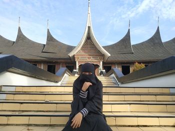 Midsection of man photographing against building