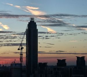 Silhouette of buildings against cloudy sky