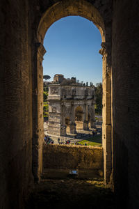 Buildings against clear sky seen through old ruin