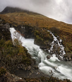 Scenic view of waterfall against sky