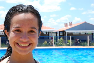 Close-up portrait of smiling young woman in swimming pool