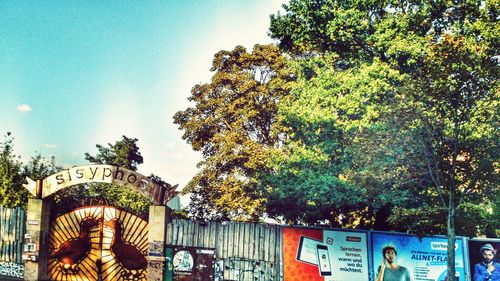 Low angle view of trees against sky in city