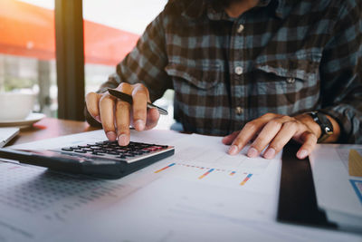 Midsection of man using laptop on table