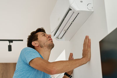 Side view of young man using mobile phone