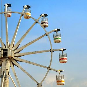 Low angle view of ferris wheel against clear blue sky