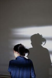 Rear view of people looking at wall