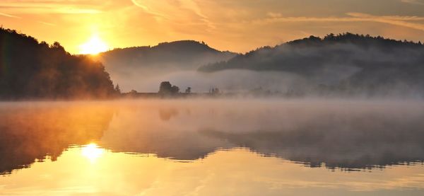 Scenic view of lake against sky during sunset