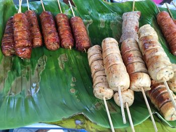 High angle view of meat with skewers on banana leaf