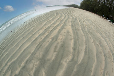 Sand dune on beach against sky