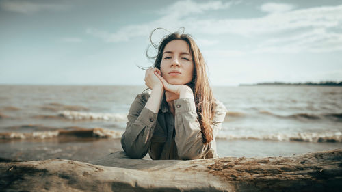 Portrait of young woman standing at beach