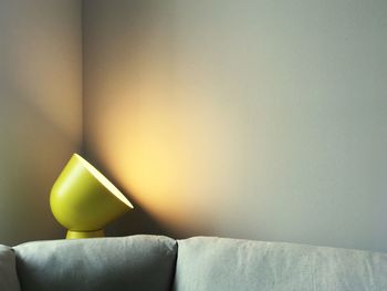 Close-up of yellow sofa against wall at home