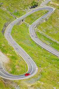 High angle view of red car on winding country road