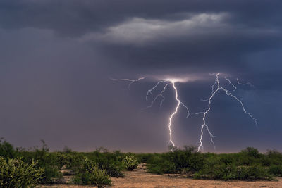 Scenic view of lightning over landscape against sky