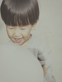 Close-up of happy boy against white background