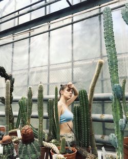 Young woman looking at potted plants