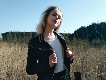 Portrait woman standing on field against sky