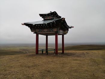 Lifeguard hut on field against sky