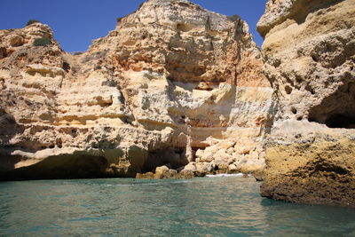 Rock formations in sea against sky