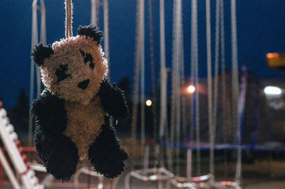 Close-up stuffed toy hanging at night