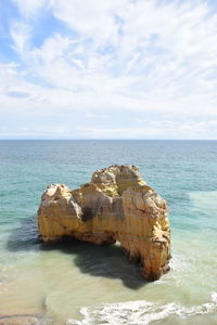 Scenic view of rocks in sea against sky