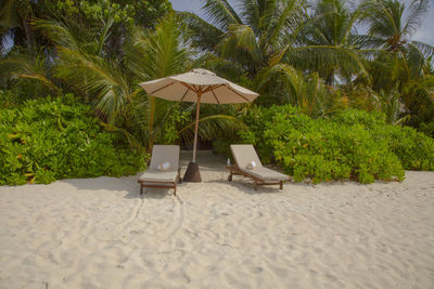 Lounge chairs and tables on sand at beach