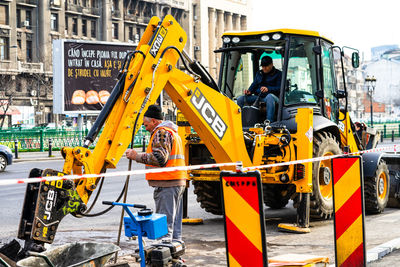 People working at construction site in city