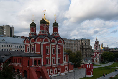 Buildings in city against cloudy sky