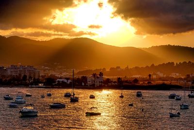 Sailboats in sea against sky during sunset
