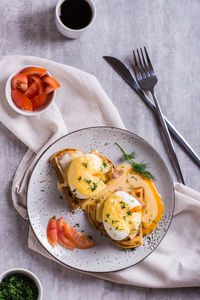 Delicious homemade breakfast with waffles, bacon and eggs benedict on a plate. top and vertical view