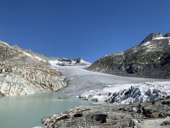 Scenic view of snowcapped mountains against clear blue sky