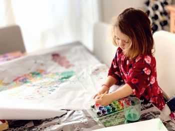 Rear view of girl sitting at home