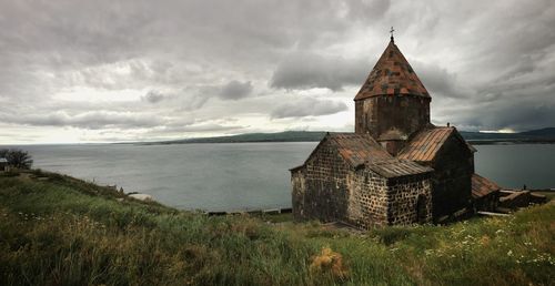 Sevanavank monastery by lake sevan against cloudy sky