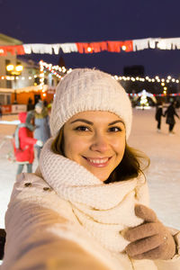Portrait of smiling woman in snow at night