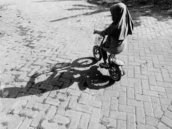 Full length of girl riding bicycle on footpath