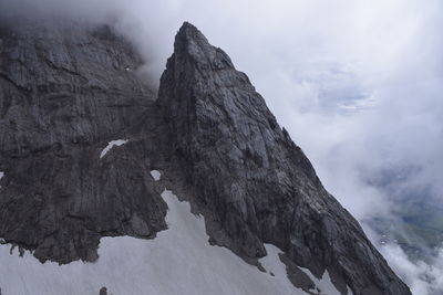 Low angle view of rock formation against sky during winter