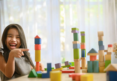 Portrait of happy girl with toy on table