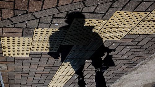 Shadow of man standing on cobblestone