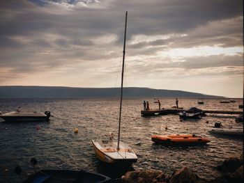 Boats in sea at sunset