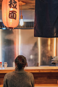 Rear view of woman sitting in restaurant