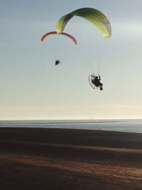 Man jumping over sea against sky