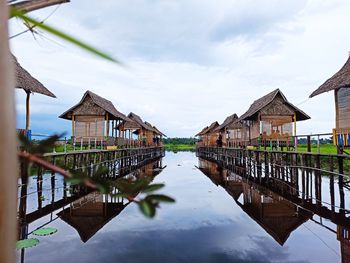 Wooden posts amidst houses and buildings against sky