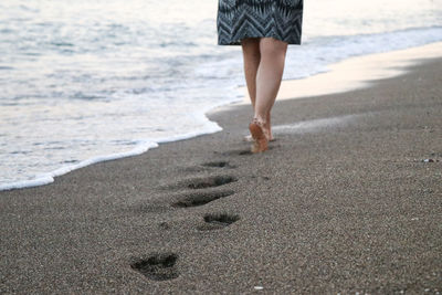 Low section of woman walking on beach