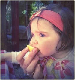 Cropped hand of mother feeding daughter at restaurant