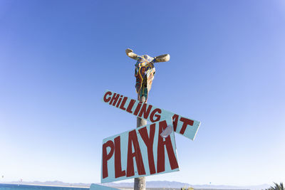 Low angle view of sign against clear sky