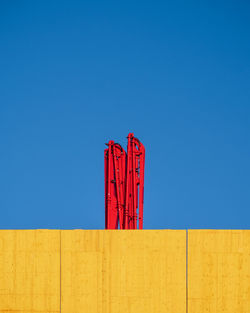 Low angle view of red building against clear blue sky