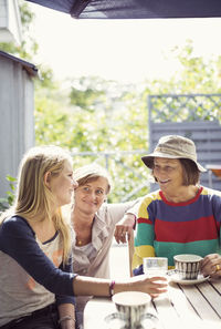 Three generation females having coffee in yard